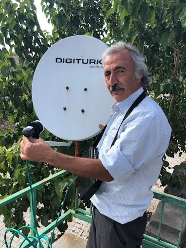 Uydu çanak anteninde sinyal ayarı yapan teknisyen